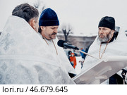Saint Petersburg, Russia, 19 January 2022, Priest consecrate water, hold cross. Редакционное фото, фотограф Spirit River / Фотобанк Лори