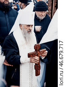 Saint Petersburg, Russia, 19 January 2022, Priest consecrate water, hold cross. Редакционное фото, фотограф Spirit River / Фотобанк Лори