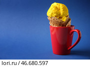 Вафельный рожок с вкусным мороженым в чашке на цветном фоне. Стоковое фото, фотограф Pixel_shot / Фотобанк Лори