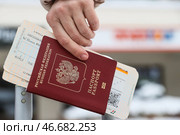Заграничный паспорт гражданина Российской Федерации и посадочные талоны в руке. Стоковое фото, фотограф Сергей Булкин/NEWS.ru / ТАСС / Фотобанк Лори