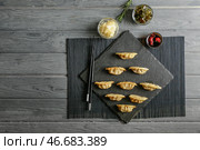 Грифельная тарелка с вкусной японской гёдзой на деревянном столе. Стоковое фото, фотограф Pixel_shot / Фотобанк Лори