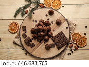Доска со вкусными сладкими трюфелями и шоколадом на деревянном столе. Стоковое фото, фотограф Pixel_shot / Фотобанк Лори