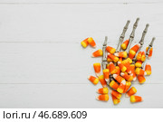 Вкусные хэллоуинские конфеты "корн" и скелетная рука на светлом деревянном фоне. Стоковое фото, фотограф Pixel_shot / Фотобанк Лори