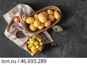 Вареные и сырые маленькие картофелины на черном фоне. Стоковое фото, фотограф Pixel_shot / Фотобанк Лори
