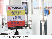 Табличка компании Air China с надписями для пассажиров первого класса, бизнес класса и со статусом Star Alliance Gold. Ухань, Китай (2024 год). Редакционное фото, фотограф Кекяляйнен Андрей / Фотобанк Лори