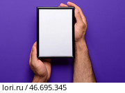 Мужчина держит пустую фоторамку на фоне фиолетового цвета. Стоковое фото, фотограф Pixel_shot / Фотобанк Лори