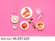 Композиция со спелыми грейпфрутами, кожурой и бокалами на розовом фоне. Стоковое фото, фотограф Pixel_shot / Фотобанк Лори