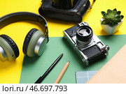 Композиция с винтажной фотокамерой, наушниками и канцелярскими принадлежностями на цветном фоне. Стоковое фото, фотограф Pixel_shot / Фотобанк Лори