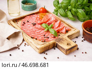 Деревянная доска с ломтями вкусной салями на светлом фоне. Стоковое фото, фотограф Pixel_shot / Фотобанк Лори