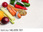 Деревянная ложка с ростками микрозелени, свежими овощами и измерительной лентой на светлом фоне. Концепция диеты. Стоковое фото, фотограф Pixel_shot / Фотобанк Лори