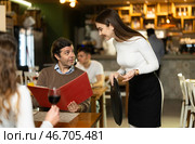 Girl waiter communicates with male customer, serve couple in restaurant. Стоковое фото, фотограф Яков Филимонов / Фотобанк Лори
