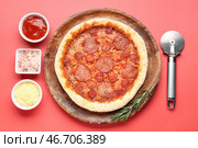 Доска с вкусной пиццей пепперони и резаком на красном фоне. Стоковое фото, фотограф Pixel_shot / Фотобанк Лори