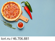 Доска с вкусной пиццей пепперони и перцем халапеньо на синем фоне. Стоковое фото, фотограф Pixel_shot / Фотобанк Лори