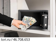 Бизнесвумен берет деньги из открытого сейфа в офисе, крупным планом. Стоковое фото, фотограф Pixel_shot / Фотобанк Лори