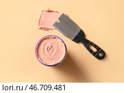 Нож с замазкой на бежевом фоне. Стоковое фото, фотограф Pixel_shot / Фотобанк Лори