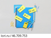 Школьные канцелярские принадлежности с различными математическими формулами и уравнениями на сером фоне. Стоковое фото, фотограф Pixel_shot / Фотобанк Лори