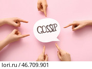 Женщина указывает на речевой пузырь со словом "СПЛЕТНИ" на розовом фоне. Стоковое фото, фотограф Pixel_shot / Фотобанк Лори