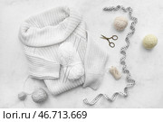 Вязаный свитер, клубки пряжи и измерительная лента на белом фоне. Стоковое фото, фотограф Pixel_shot / Фотобанк Лори