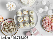 Десертный стенд с вкусными белыми капкейками и другими сладостями для дня рождения на столе. Стоковое фото, фотограф Pixel_shot / Фотобанк Лори