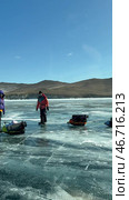 LAKE BAIKAL, KHUZHIR VILLAGE, OLKHON ISLAND, IRKUTSK REGION, RUSSIA -  February 28, 2025: Vertical video of hikers traveling on ice of frozen Maloe More with tents on sleds. Редакционное видео, видеограф Виктория Катьянова / Фотобанк Лори