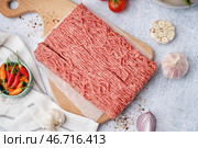 Деревянная доска с свежим мясом, измельченным с приправами на белом фоне. Стоковое фото, фотограф Pixel_shot / Фотобанк Лори