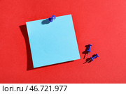 Синяя бумажная записка, прикрепленная на красный фон. Стоковое фото, фотограф Pixel_shot / Фотобанк Лори