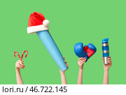 Женские руки держат спортивную бутылку, боксерские перчатки, леденец, йога-мат и шапку Санты на зеленом фоне. Рождественская спортивная композиция. Стоковое фото, фотограф Pixel_shot / Фотобанк Лори