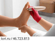 Молодая женщина делает педикюр с использованием фрезера в спа-салоне. Стоковое фото, фотограф Pixel_shot / Фотобанк Лори