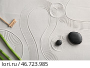 Камни, маленькие грабли и бамбуковые стебли на светлом песке с линиями. Концепция дзен. Стоковое фото, фотограф Pixel_shot / Фотобанк Лори