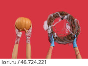 Руки зомби с тыквой и венком на Хэллоуин на красном фоне. Стоковое фото, фотограф Pixel_shot / Фотобанк Лори