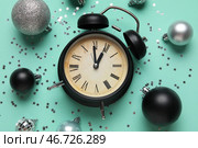 Композиция с будильником, рождественскими шарами и конфетти на бирюзовом фоне. Концепция обратного отсчета до Рождества. Крупный план. Стоковое фото, фотограф Pixel_shot / Фотобанк Лори