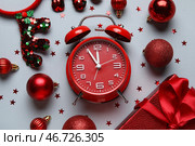 Композиция с красным будильником, украшениями и конфетти на сером фоне. Концепция обратного отсчета до Рождества. Крупный план. Стоковое фото, фотограф Pixel_shot / Фотобанк Лори