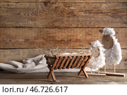 Мангер с ребенком и игрушечной овечкой на деревянном фоне. Концепция рождественской истории. Стоковое фото, фотограф Pixel_shot / Фотобанк Лори