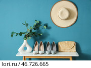 Туфли и клатч на столе возле синей стены в комнате. Стоковое фото, фотограф Pixel_shot / Фотобанк Лори