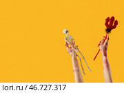 Зомби-руки со скелетом и трезубцем дьявола на желтом фоне. Празднование Хэллоуина. Стоковое фото, фотограф Pixel_shot / Фотобанк Лори