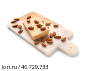 Разделочная доска с вкусным марципановым батончиком и миндальными орехами на белом фоне. Стоковое фото, фотограф Pixel_shot / Фотобанк Лори