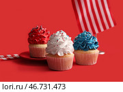 Вкусные патриотичные кексы с флагом США на красном фоне. День независимости Америки. Стоковое фото, фотограф Pixel_shot / Фотобанк Лори