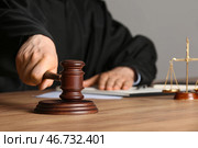 Мужчина-судья с молотком, весами правосудия и документами за столом в офисе. Стоковое фото, фотограф Pixel_shot / Фотобанк Лори