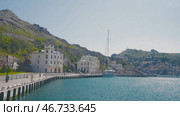Sea tourist city on background of green mountains and bright sun. Стоковое фото, фотограф David Kashakhi / Фотобанк Лори