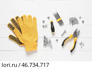 Болты с полным резьбовым стержнем, перчатки и инструменты на белом деревянном фоне. Стоковое фото, фотограф Pixel_shot / Фотобанк Лори