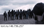 Man sits in a chair and looks at a group of masked criminals. Стоковое фото, фотограф David Kashakhi / Фотобанк Лори