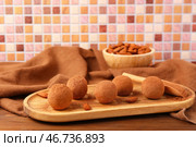 Доска с вкусными марципановыми конфетами, покрытыми какао-порошком и миндалем, на деревянном столе. Стоковое фото, фотограф Pixel_shot / Фотобанк Лори