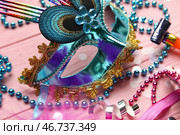 Красивая карнавальная маска с праздничными дудками, конфетти и бусинами на розовом деревянном фоне. Крупный план. Стоковое фото, фотограф Pixel_shot / Фотобанк Лори