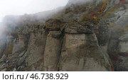 Top view of rock plunging into cold autumn fog. Стоковое фото, фотограф David Kashakhi / Фотобанк Лори