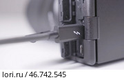 Close-up of wired charging of black electronic device. Стоковое фото, фотограф David Kashakhi / Фотобанк Лори