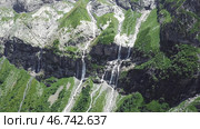 Waterfall flowing down from high mountains on a Sunny day. Стоковое фото, фотограф David Kashakhi / Фотобанк Лори