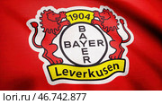 Close-up of waving flag with FC Bayer Leverkusen football club logo, seamless loop. Стоковое фото, фотограф David Kashakhi / Фотобанк Лори