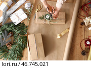 Молодая женщина заворачивает подарок на столе, вид сверху. Стоковое фото, фотограф Pixel_shot / Фотобанк Лори
