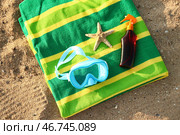 Новая плавательная маска, солнцезащитный спрей, морская звезда и полотенце на песке. Стоковое фото, фотограф Pixel_shot / Фотобанк Лори