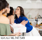 Hospitable hostess kissing female friends arriving for home get-together. Стоковое фото, фотограф Яков Филимонов / Фотобанк Лори